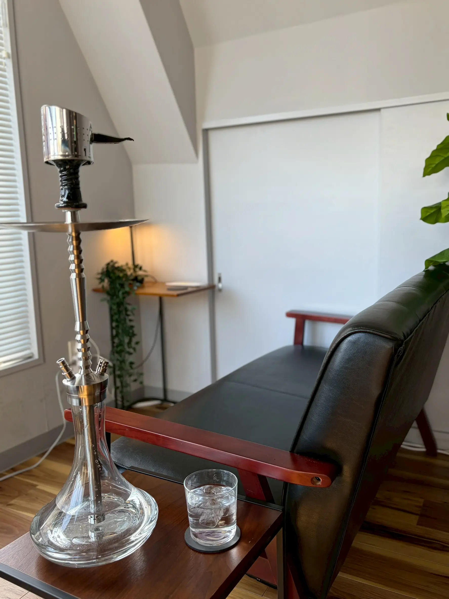 A window-side sofa seat at shisha bar IORI with a hookah on the table