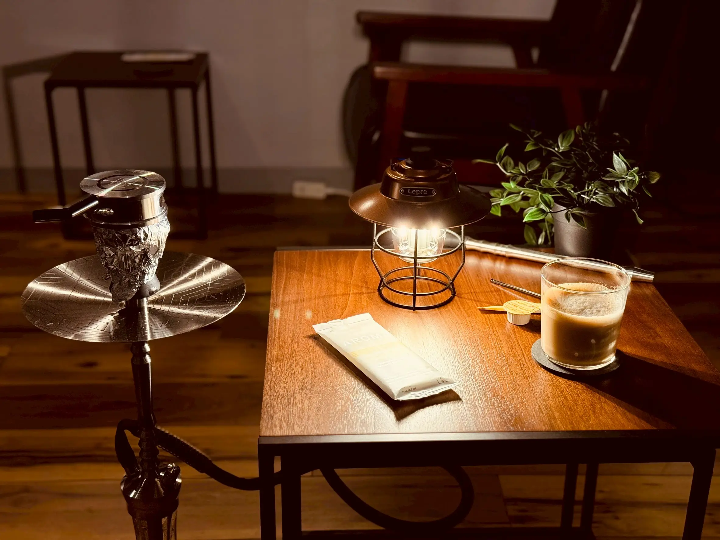 A lantern-lit table with a hookah at shisha bar IORI