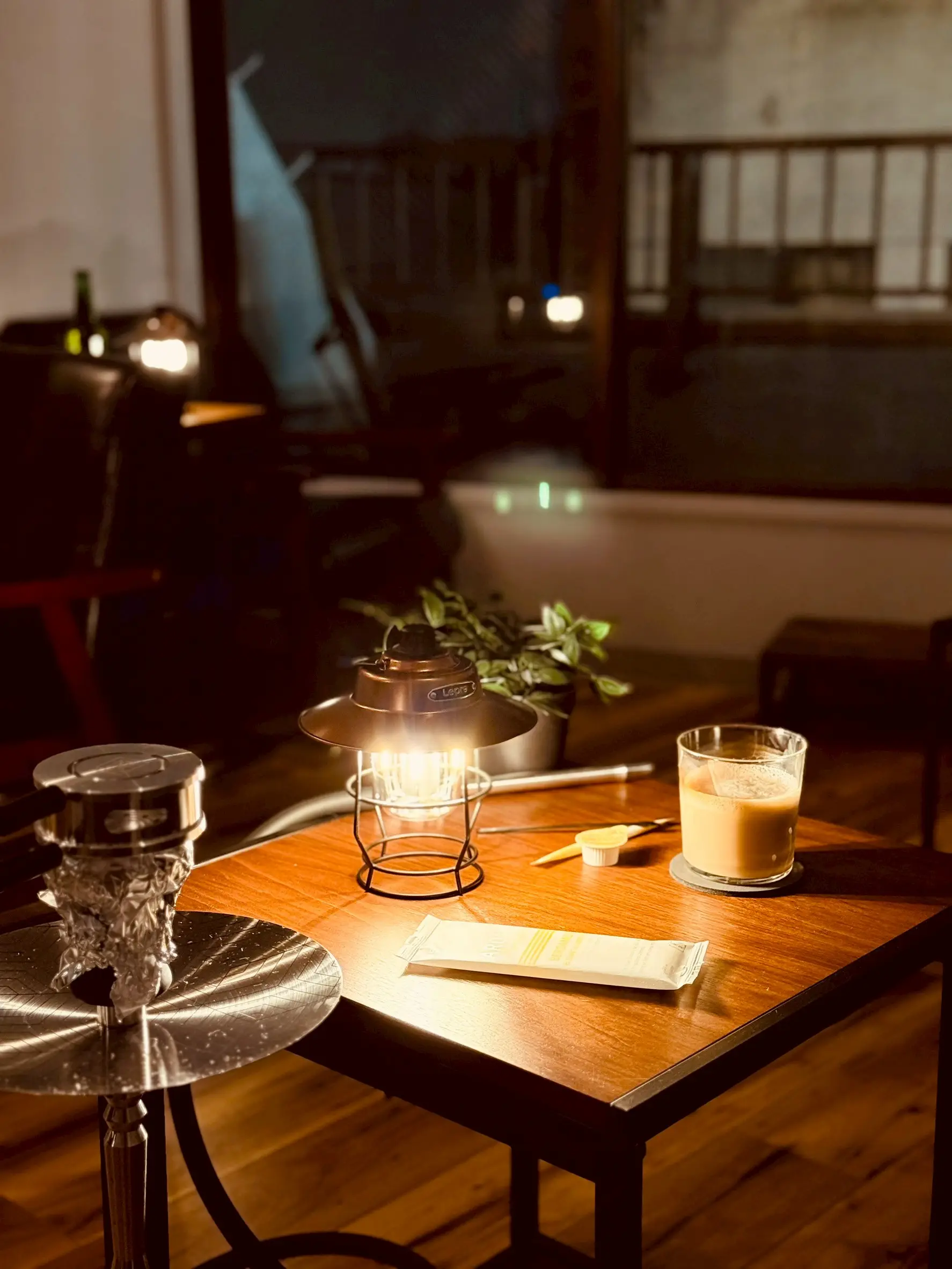 shisha bar IORI at night: a lamp-lit table with a hookah and a drink